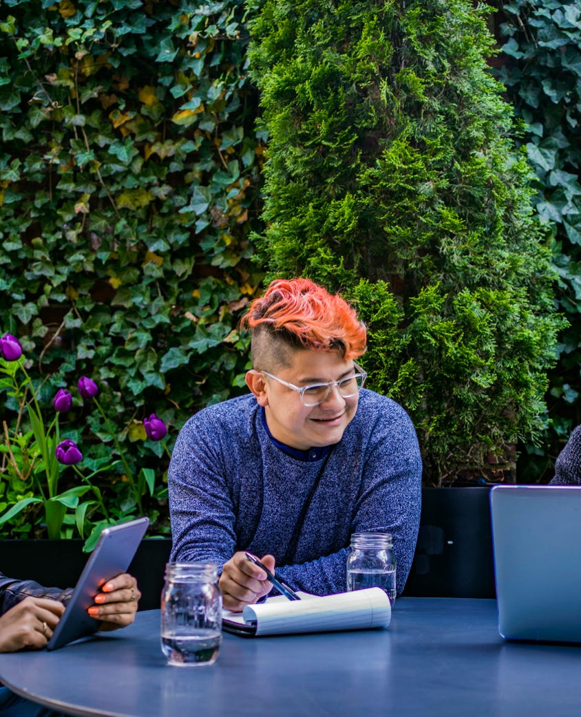 Two Men and Woman Sitting in Front of Blue Table